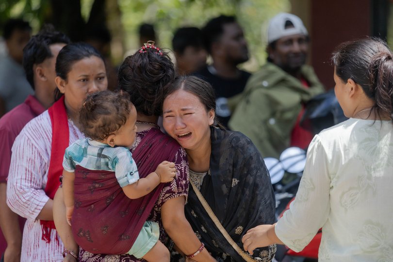 People await news of their missing family members after a massive flash flood.
