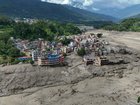 Damaged houses stand precariously on the banks of the Trishuli river after flash floods in Nepal. (EPA PHOTO)