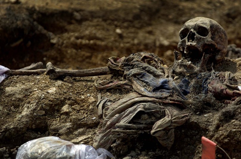  The body of a victim of the Srebrenica massacre, the worst ethnically motivated mass murder on the continent since World War II, lies in a mass grave in Budak, Bosnia on July 9, 2005. 