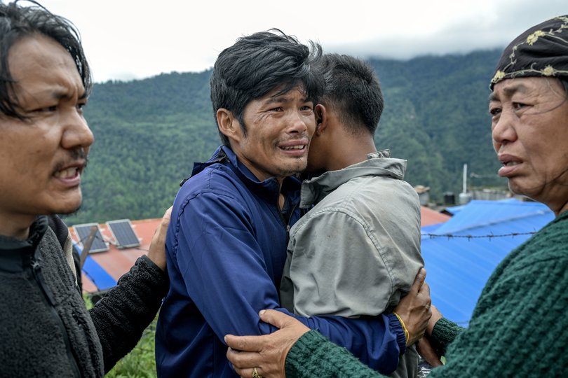 A man is overcome as he waits for his turn to board a rescue helicopter in the disaster-stricken Rasuwa district.