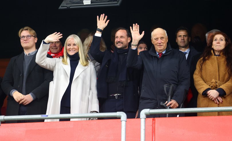 Harald V of Norway (R), Crown Prince Haakon of Norway (C) and Mette-Marit Tjessem Hoiby (L) wave to the crowd from their seats during the FIFA World Cup 2026 qualifier match between Norway and Estonia at Ullevaal Stadion on November 13, 2025 in Oslo, Norway.
