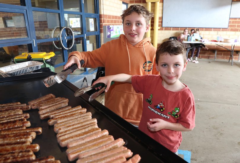 Levi (7) and Zac (11) with their Democracy Sausage at Singleton Primary School.