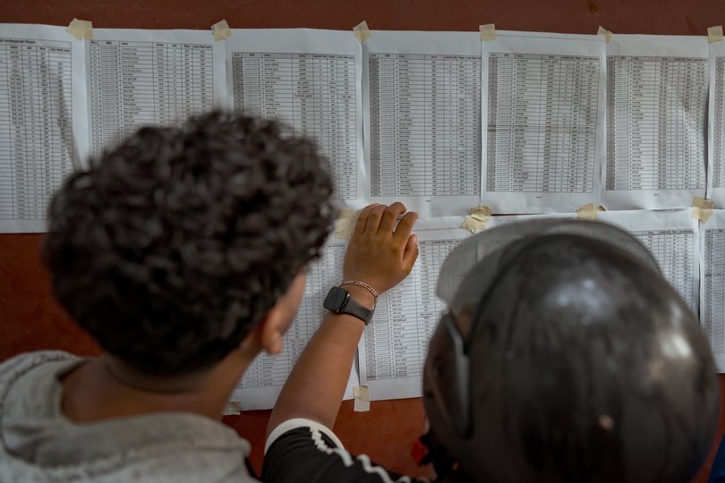 People searching for missing relatives look at a list of names.