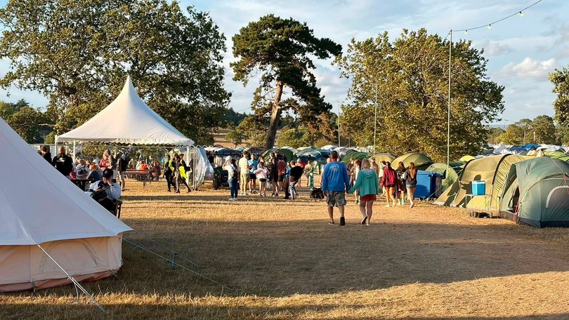 A man has been killed and six other people injured after a large sign toppled over and crushed festival-goers in England.