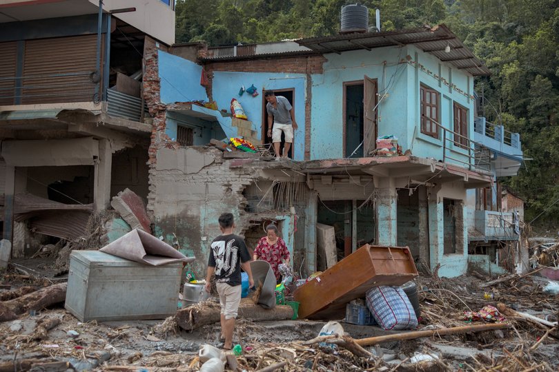 Residents salvage belongings from their destroyed home.