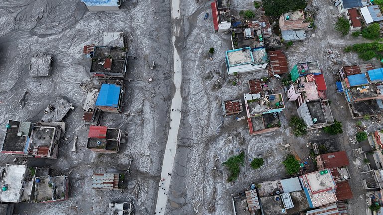 An Aerial view shows debris and mud covering an area following flash floods on August 28, 2026 in DevGhat village, Nepal. 