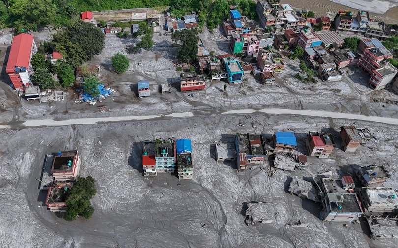 An aerial view shows debris and mud covering an area following flash floods on August 28, 2026 in DevGhat village, Nepal.