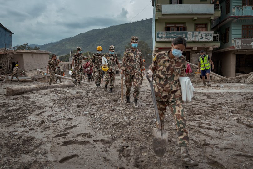 Soldiers search for bodies.