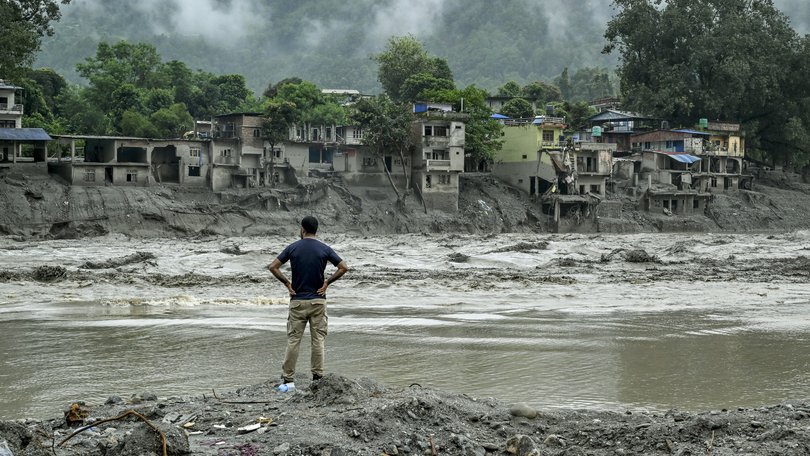 A resident surveys houses destroyed by the flash flood next to the river in Devighat, Nepal.