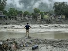 A resident surveys houses destroyed by the flash flood next to the river in Devighat, Nepal.