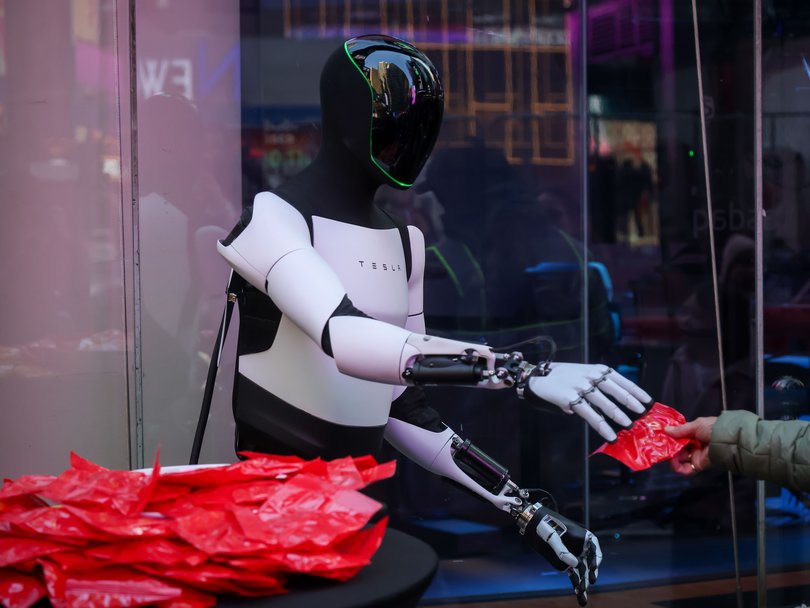 A Tesla Optimus robot hands out candy in New York.