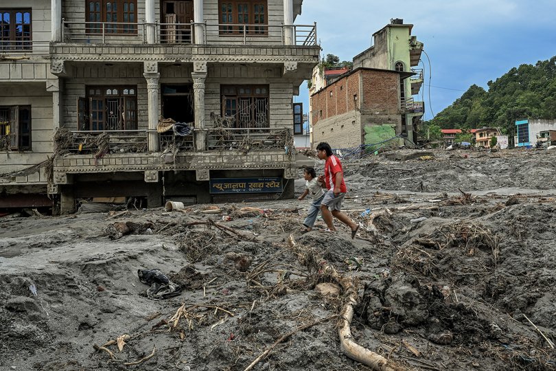 Houses damaged and partially submerged in thick mud and debris from the flood, in Devighat, Nepal.