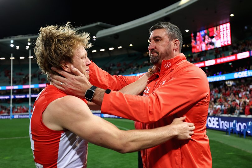 Callum Mills of the Swans embraces Swans head coach Dean Cox after winning the round 24 AFL match between Sydney Swans and North Melbourne.