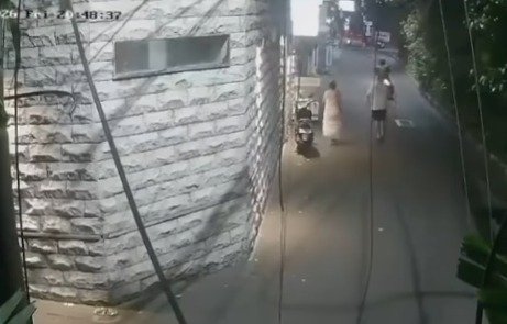 The man attempts to run after the motorbike but with no avail — it has already rounded the corner and disappeared.