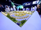 Guests look at a model of the largest data center in the UAE under construction in Abu Dhabi as the Stargate initiative, a joint venture between G42, Microsoft, and OpenAI, during the Abu Dhabi International Petroleum Exhibition & Conference (ADIPEC) in Abu Dhabi on November 3, 2025. (Photo by Giuseppe CACACE / AFP) GIUSEPPE CACACE