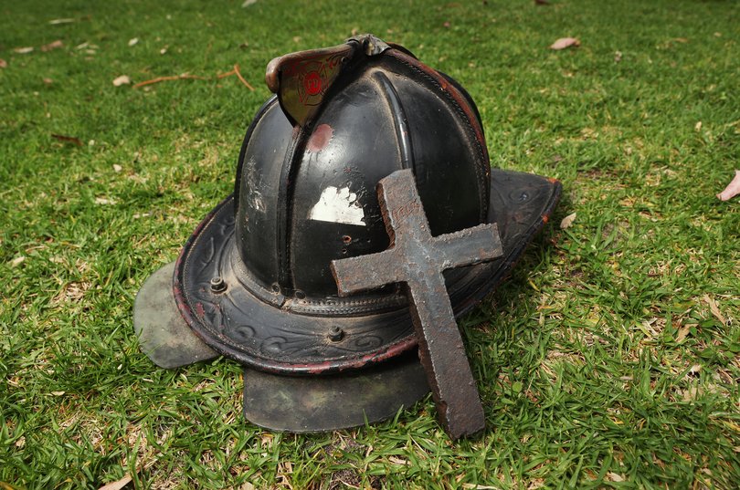 A metal crucifix, cut out of the World Trade Centre wreckage and a New York City Firefighters helmet.