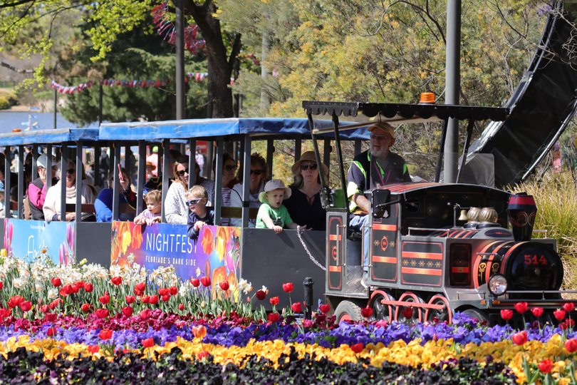 Visitors take a sightseeing train at the Floriade festival in Canberra.
