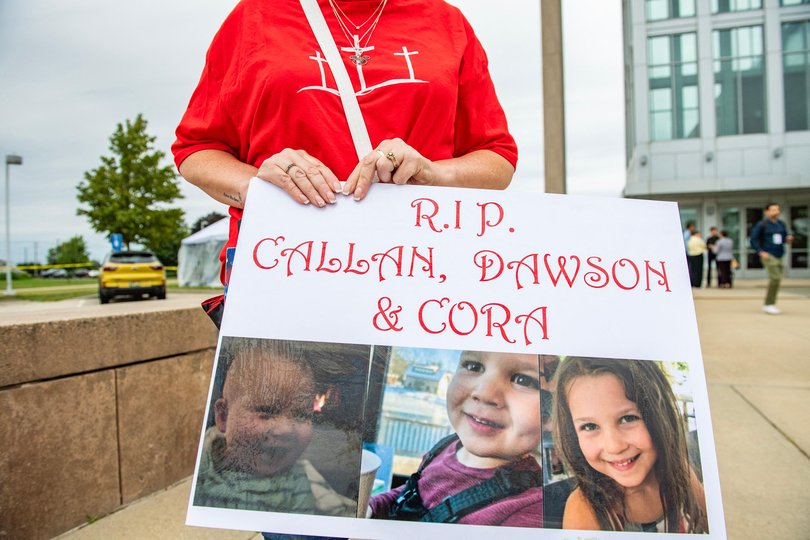 A woman carries a sign to show support for the three murdered children of Lindsay Clancy during the Clancy's murder trial.