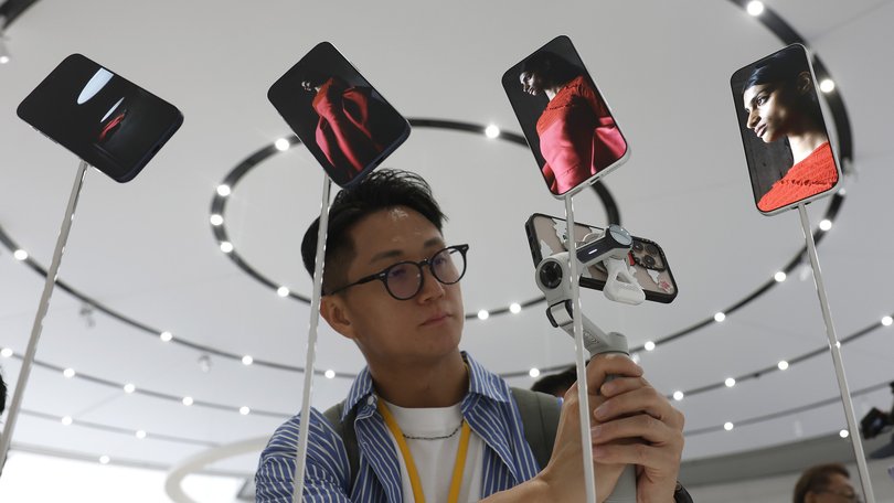 CUPERTINO, CALIFORNIA - SEPTEMBER 09: An attendee takes a video of a display of new Apple iPhone 17 Pros during an Apple special event at Apple headquarters on September 9, 2025 in Cupertino, California. Apple unveiled a new generation of iPhones, updated Apple Watches, and AirPods during a special event at its headquarters. (Photo by Justin Sullivan/Getty Images)