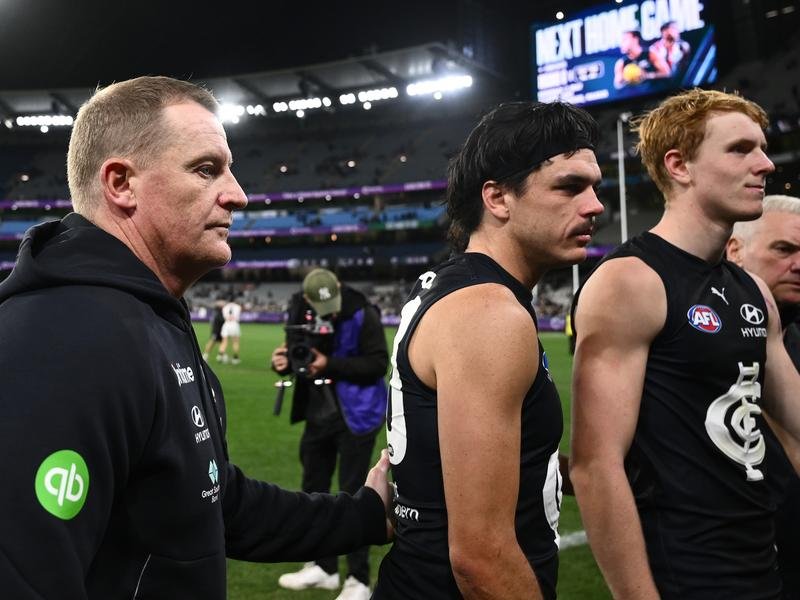 Carlton coach Michael Voss (left) and Elijah Hollands leave the MCG field after the April 16 game.