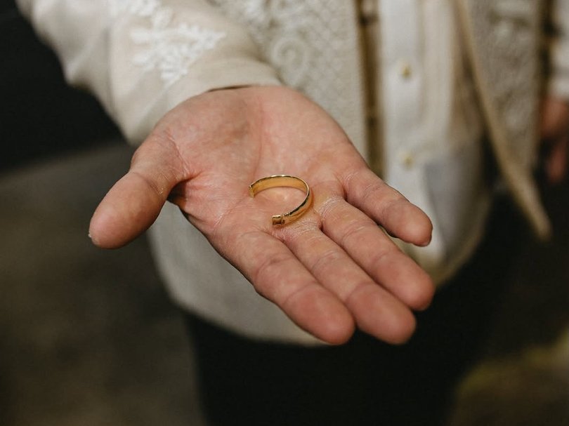 The groom showing off the cut ring.