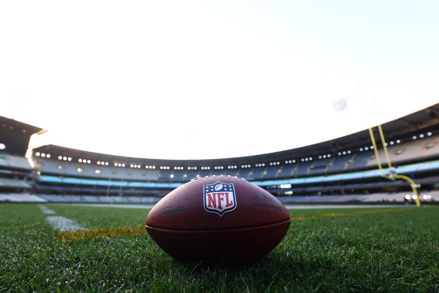 An NFL ball on the MCG turf.