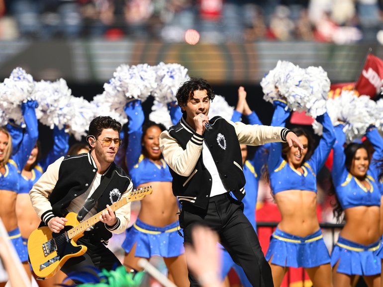 The Jonas Brothers have won over a packed MCG with a surprise tribute to Australian music icon John Farnham during the historic NFL clash in Melbourne.