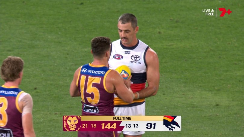 Taylor Walker receives a match ball from Dayne Zorko.