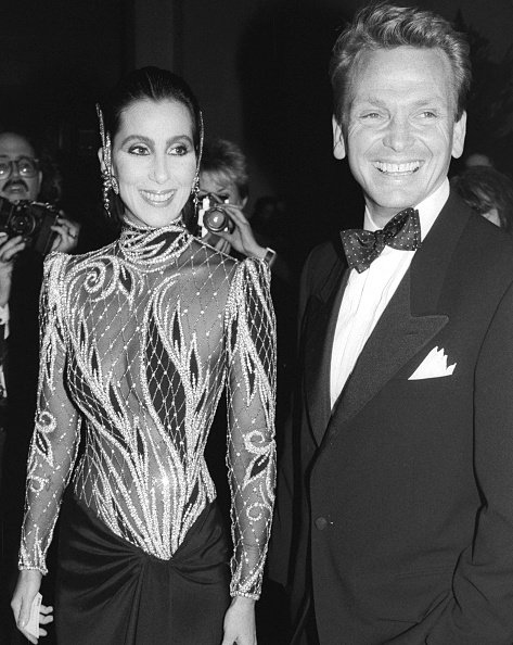 Cher arrives at Metropolitan Museum wearing Bob Mackie outfit and escorted by the designer. 