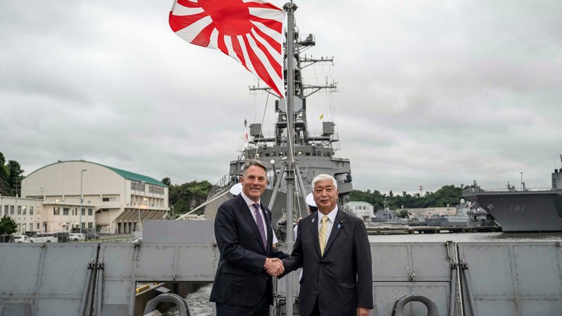 Australia's Defence Minister Richard Marles and Japan's Defence Minister Gen Nakatani shake hands.