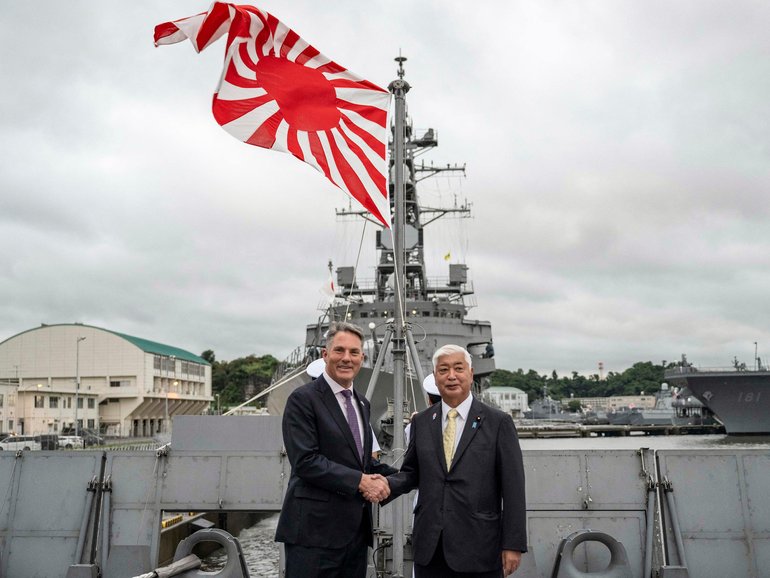 Australia's Defence Minister Richard Marles and Japan's Defence Minister Gen Nakatani shake hands.