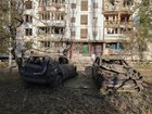 Burnt-out vehicles in front of a damaged residential building in Kyiv on Thursday. 