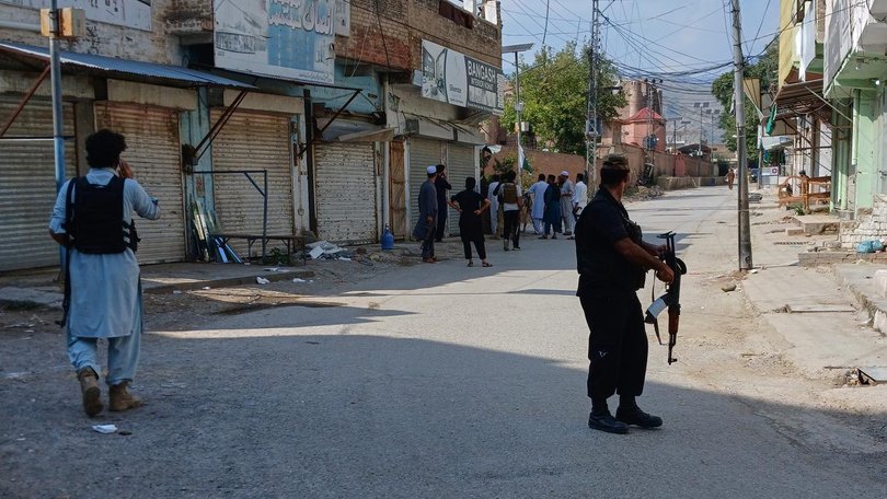 Police officers secure a road leading to the site of a bombing at a mosque in Kohat, Pakistan. (AP PHOTO)