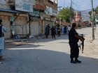 Police officers secure a road leading to the site of a bombing at a mosque in Kohat, Pakistan. (AP PHOTO)