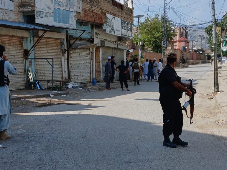 Police officers secure a road leading to the site of a bombing at a mosque in Kohat, Pakistan. (AP PHOTO)