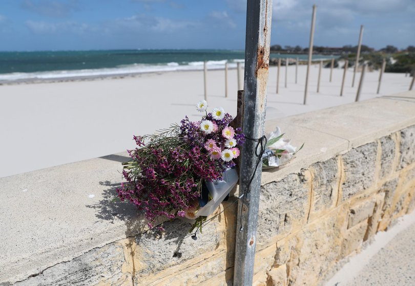 The family of the man killed in a shark attack at Sorrento Beach on Friday paid tribute to him this morning, laying flowers by a beach closure sign before leaving via a side path to avoid the media.