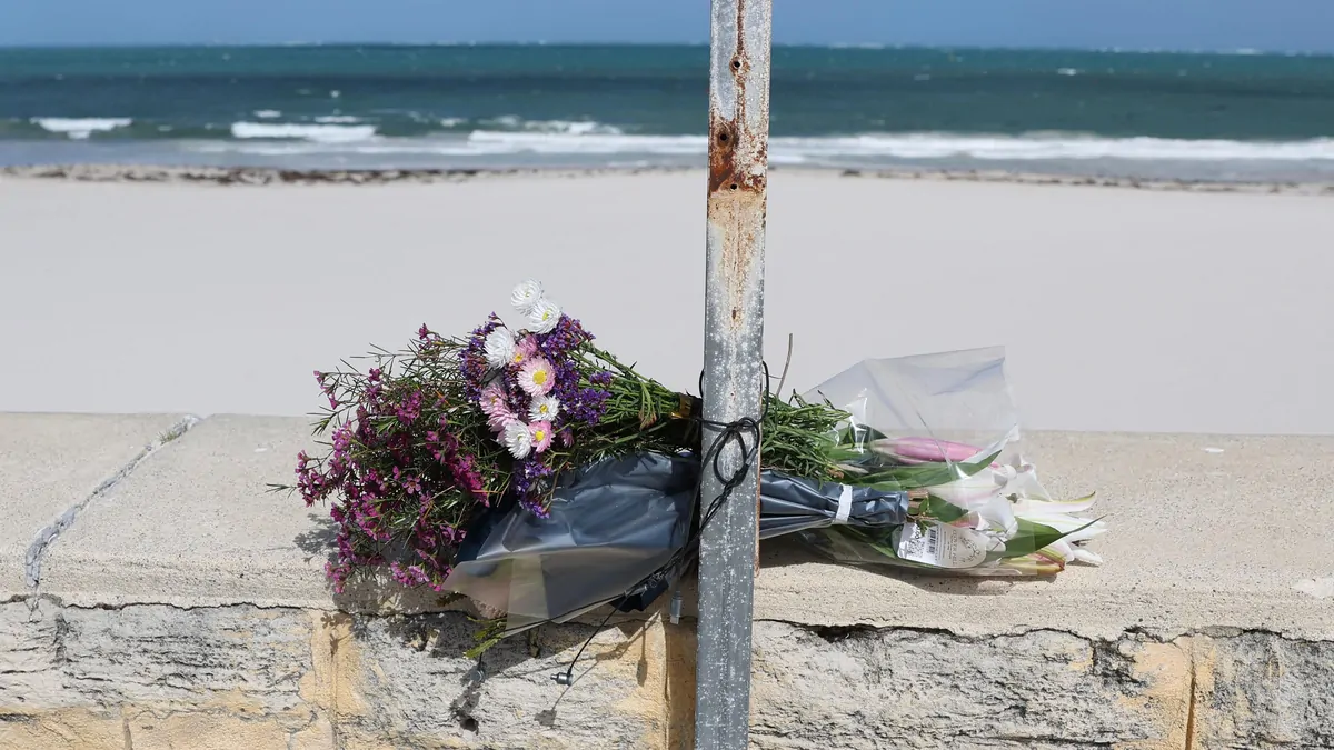 Sorrento shark attack: Victim’s family pay tribute by laying flowers by beach closure sign Sorrento shark attack: Victim’s family pay tribute by laying flowers by beach closure sign