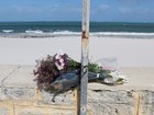 The family of the man killed in a shark attack at Sorrento Beach on Friday paid tribute to him this morning, laying flowers by a beach closure sign before leaving via a side path to avoid the media.