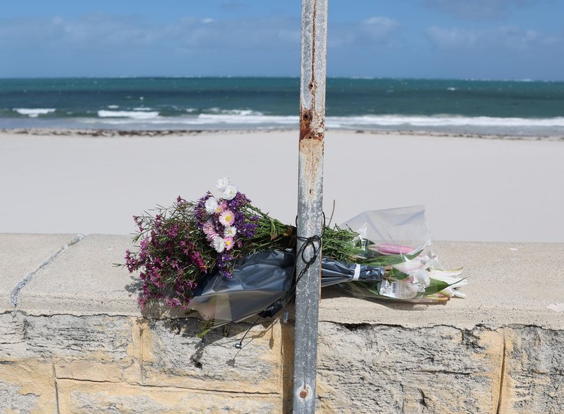 The family of the man killed in a shark attack at Sorrento Beach on Friday paid tribute to him this morning, laying flowers by a beach closure sign before leaving via a side path to avoid the media.