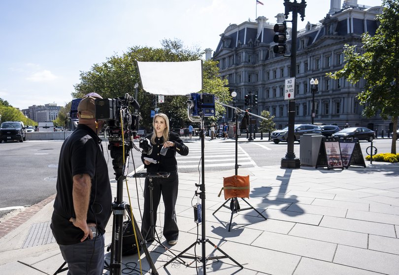 White House reporter Betsy Kline, with CNN, holds her empty credential holder after her White House credential pass was taken away by President Donald Trump.