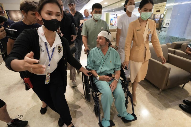 An Australian passenger, center, who was injured on a flight that was battered by severe turbulence