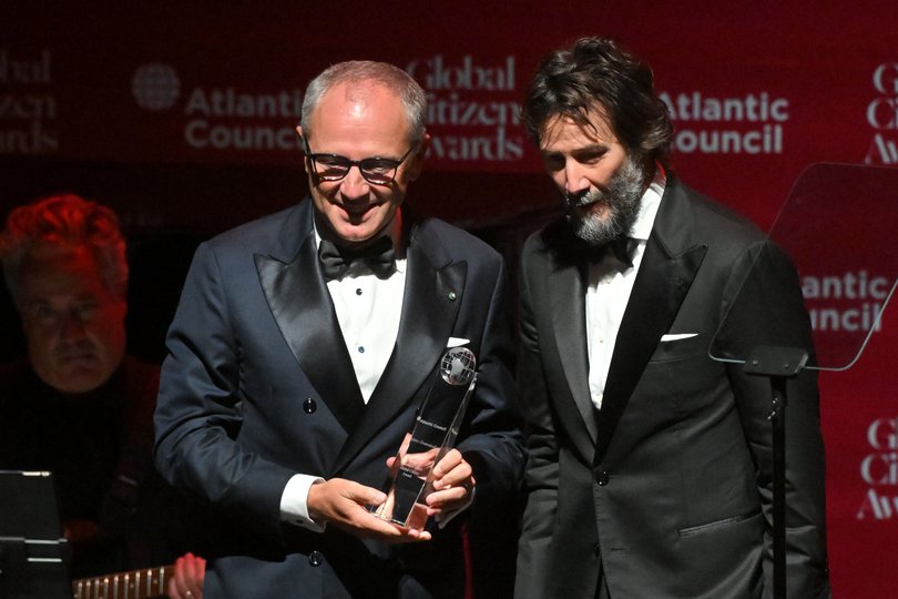 Formula 1 CEO Stefano Domenicali receives an award from actor Keanu Reeves.