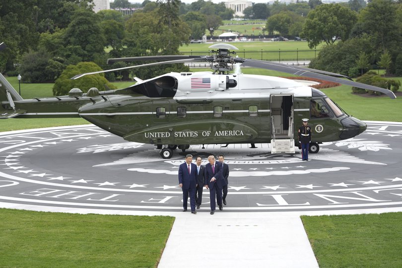 President Donald Trump and President Xi Jinping of China walk on the new helipad at the White House in Washington.