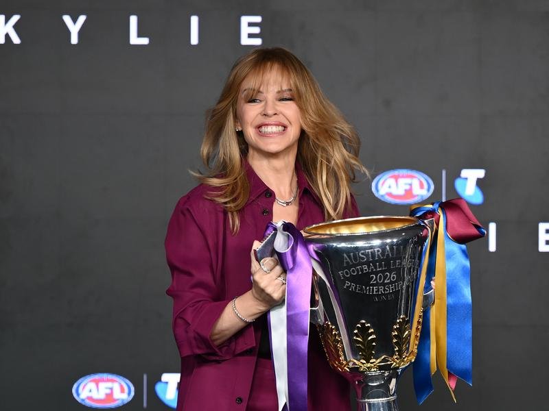 Superstar Kylie Minogue holds the premiership cup before finally performing at an AFL grand final.  (Joel Carrett/AAP PHOTOS)