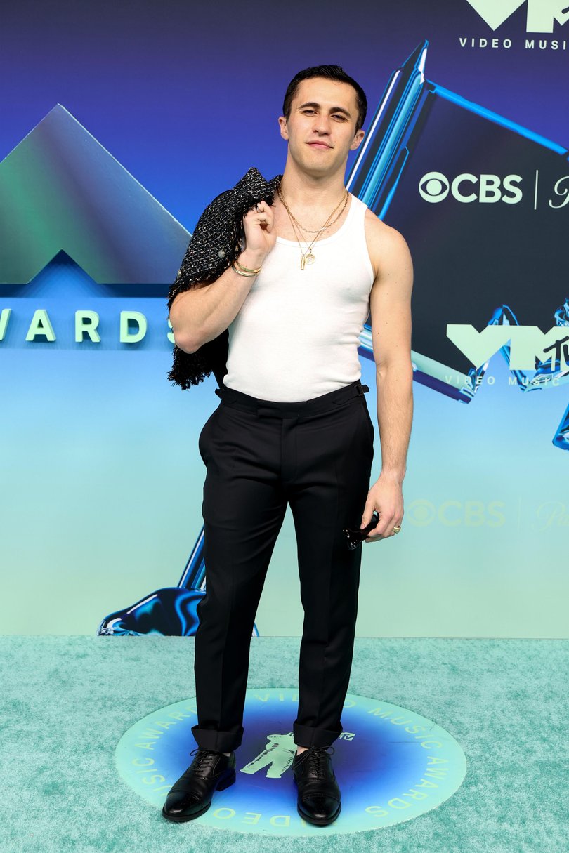 Influencer Chris Olsen may not have gotten the red carpet look memo, wearing a white tank top tucked into black pants.