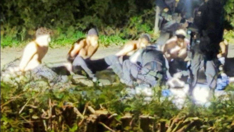Five men were pictured shirtless near RAF Fairford after being arrested.