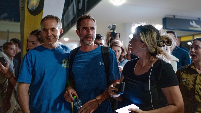 Assaf Regavim, who helped subdue the pilot during the flight, smiles as he talks with friends and relatives amidst waiting crowds at Ben Gurion Airport.