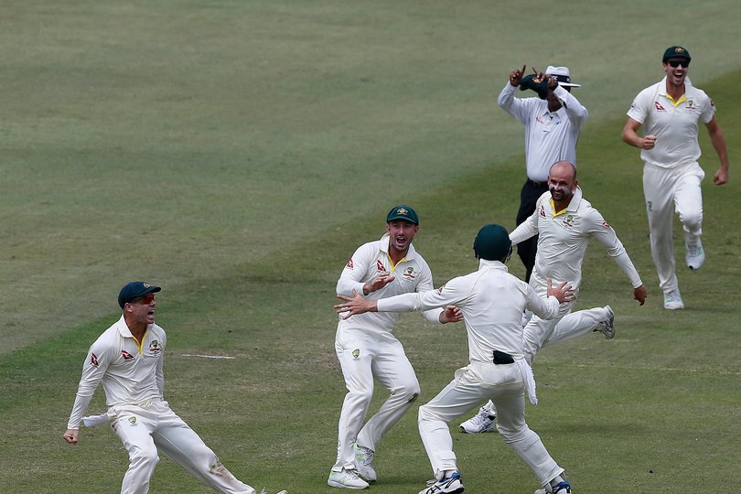 Australian bowler Nathan Lyon (3R) celebrates with teammates after taking a throw from David Warner (L) to run out unseen South African batsman AB de Villiers during the fourth day of the first Test cricket match between South Africa and Australia at The Kingsmead Stadium in Durban on March 4, 2018. (Photo by MARCO LONGARI / AFP)