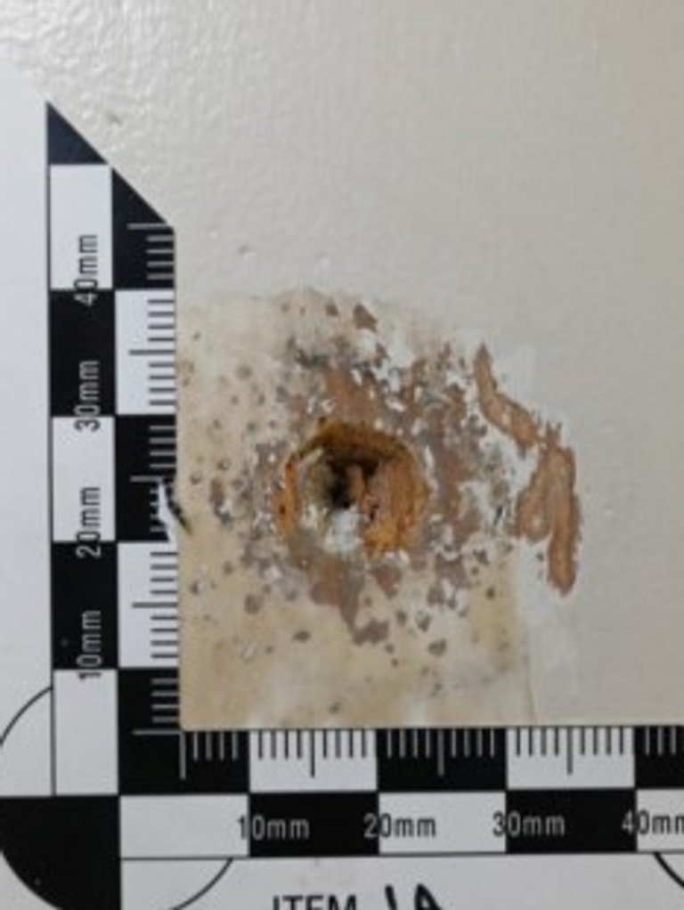 Photographs of a bullet hole in a door at Mr Baird's house, which was not discovered until July 2026. Picture: Court exhibit.