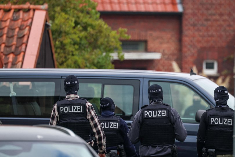 Police officers stand in front of the home of former BND President August Hanning, who was arrested  on suspicion of espionage.